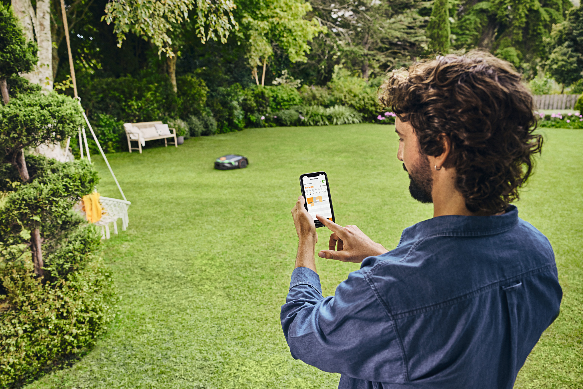 man using iMOW app to control mowing plan