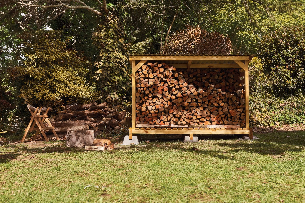 DIY firewood shelter in a garden