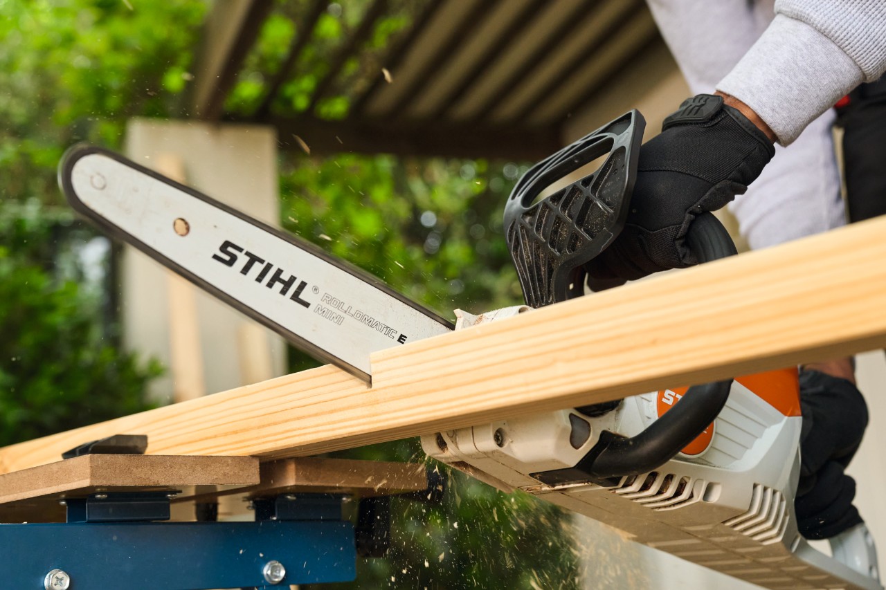 A man sawing a side strut for a football goal with a STIHL MSA 70