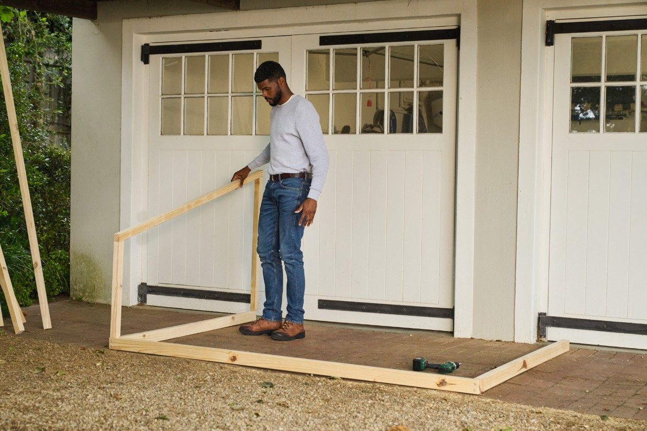 A man setting up the side wall for the goal
