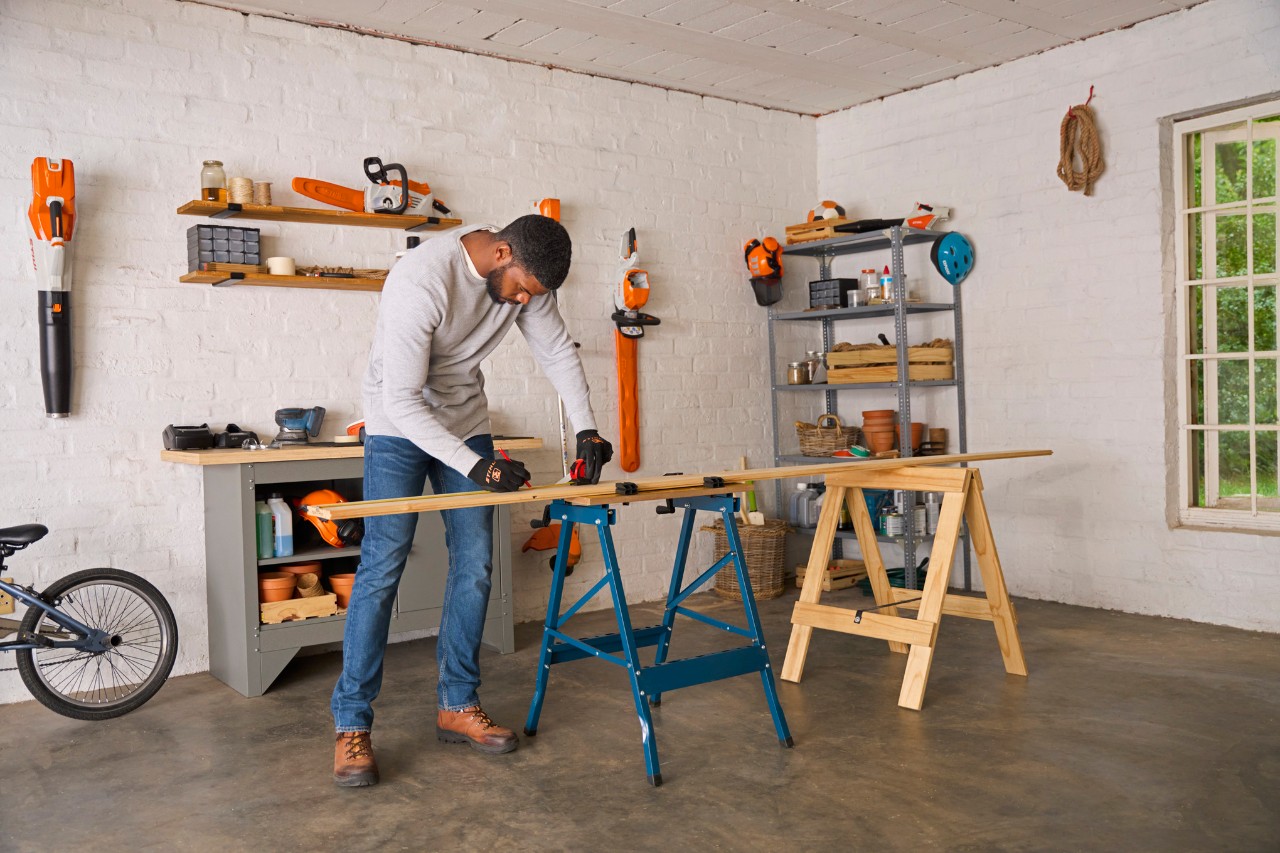 A man placing a piece of square-edge timber on a workbench