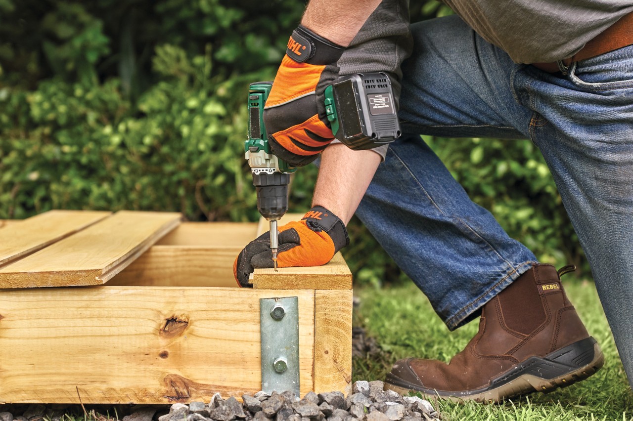 A tongue-and-groove floorboard being screwed to a timber garden shed base