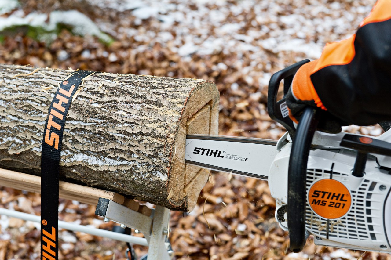 DIY lantern: a square being cut into the end face of a lashed log with a STIHL MS 201 C-M petrol chainsaw with M-Tronic