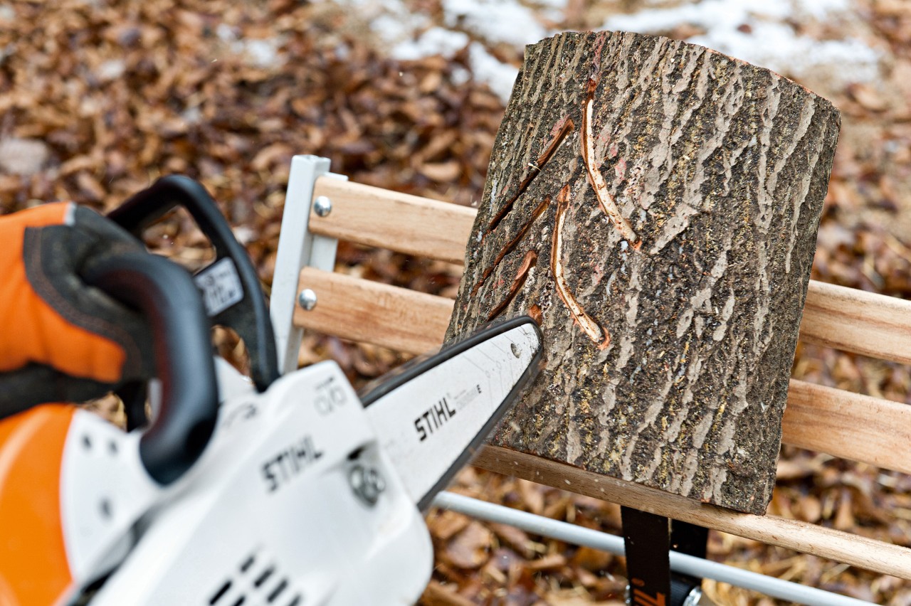 DIY log lantern: a pine tree pattern of light slits being cut with a STIHL MS 201 C-M petrol chainsaw with M-Tronic
