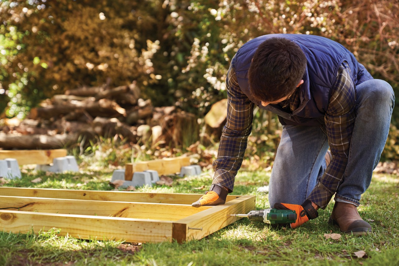 A man screws together the floor frame