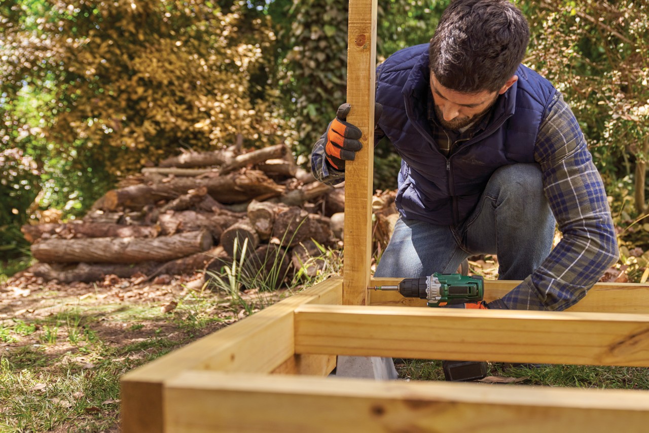A man securing an upright to an already-built floor frame