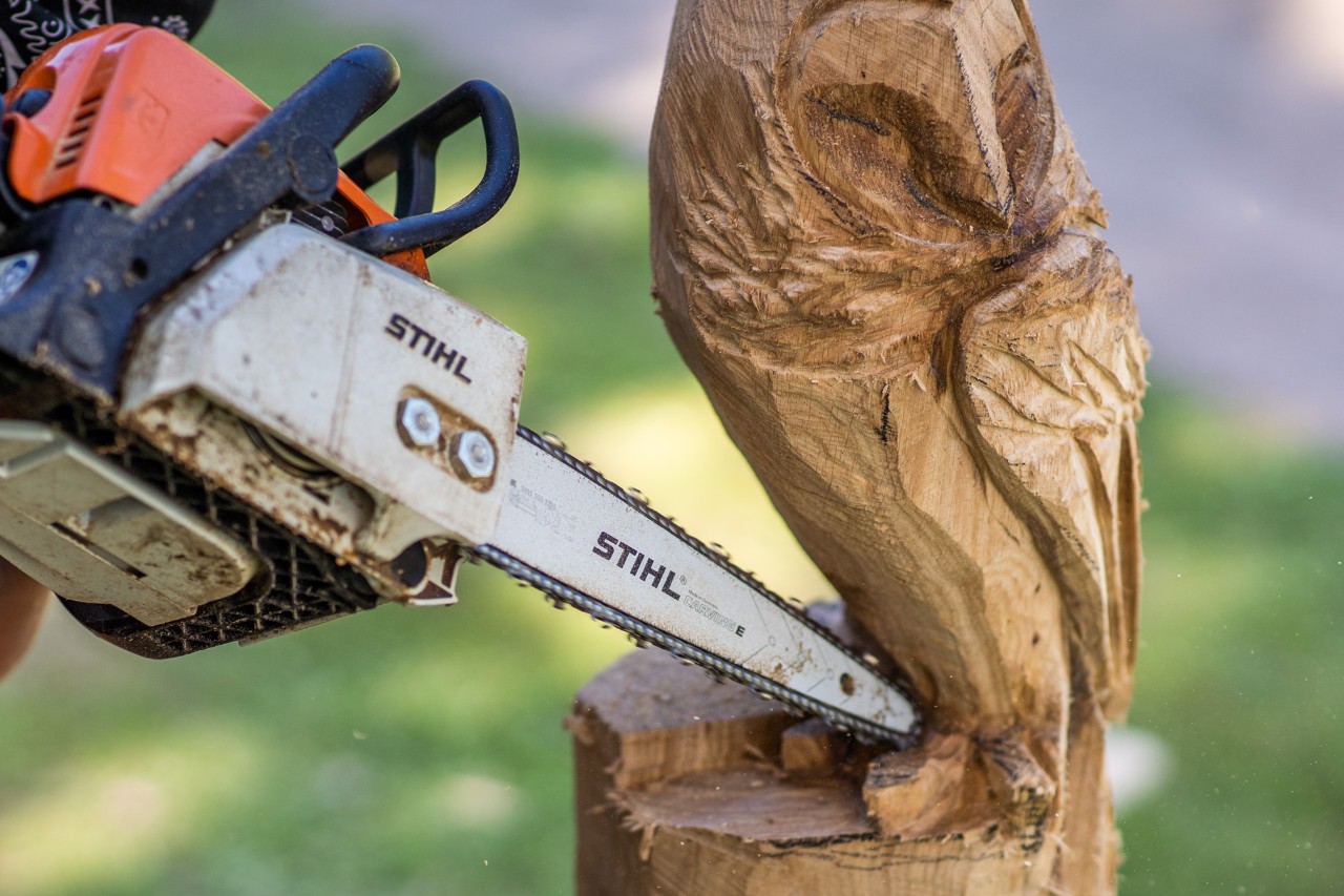 A wooden owl sculpture in progress: a STIHL chainsaw with carving set is used to carve out the wooden owl’s talons.