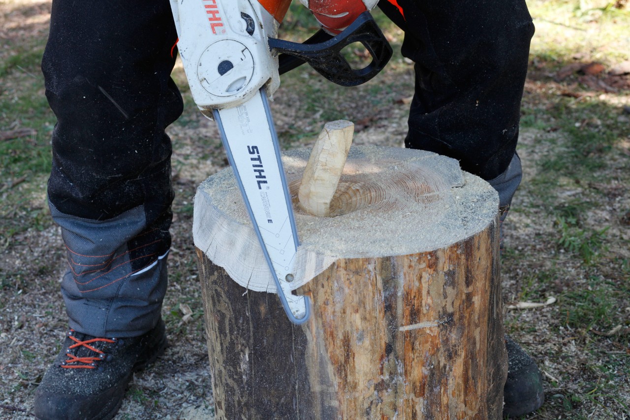 Top edges of a log being rounded off using a STIHL MSA 140 C chainsaw