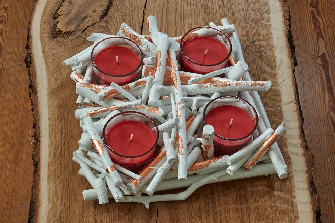 DIY advent wreath: a finished twig wreath with four red candles in glasses