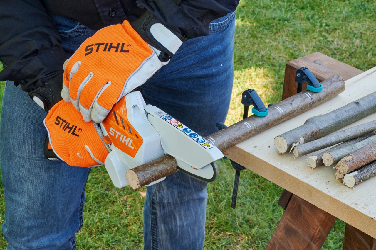 DIY decorative heart: a STIHL GTA 26 cordless garden pruner being used to cut through a branch clamped to a table