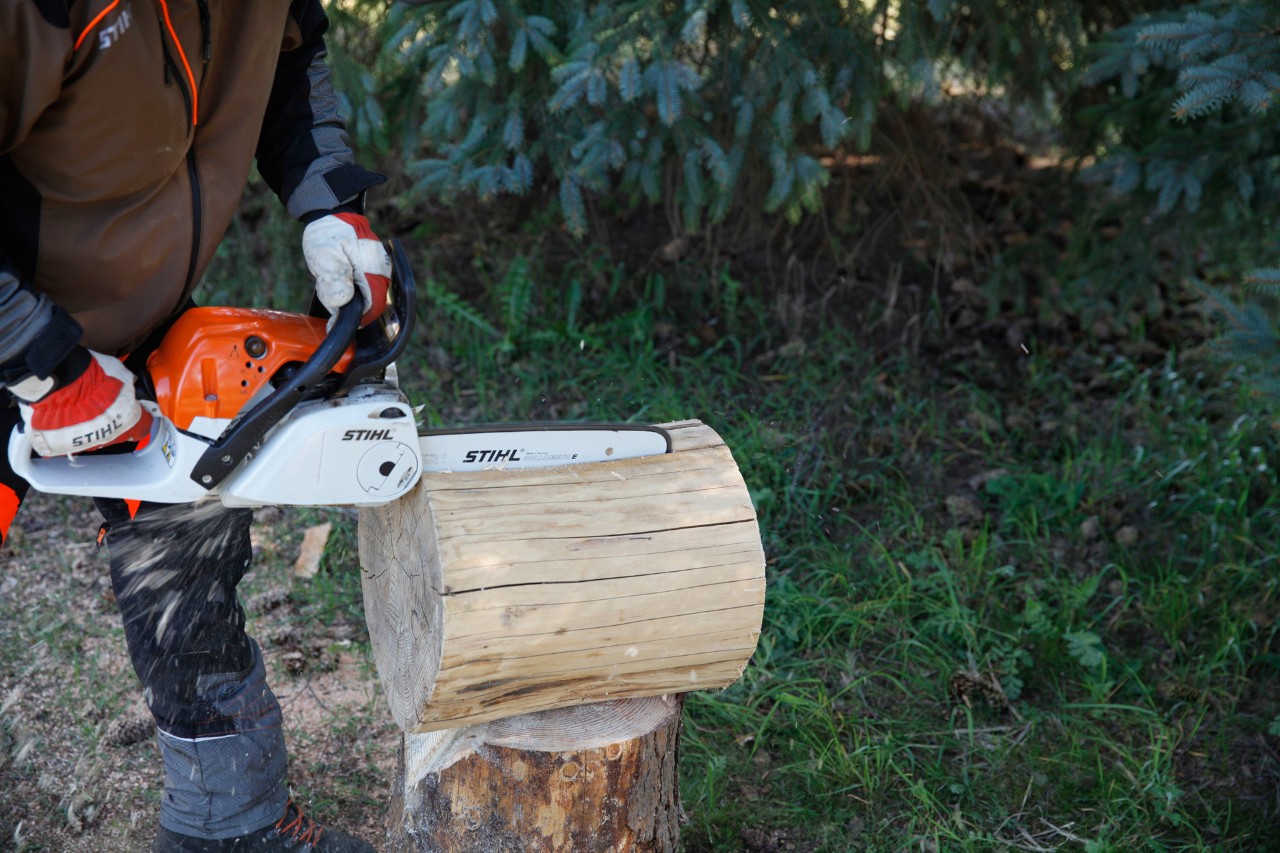A log being cut into lengthwise with a STIHL MS 231 C petrol chainsaw