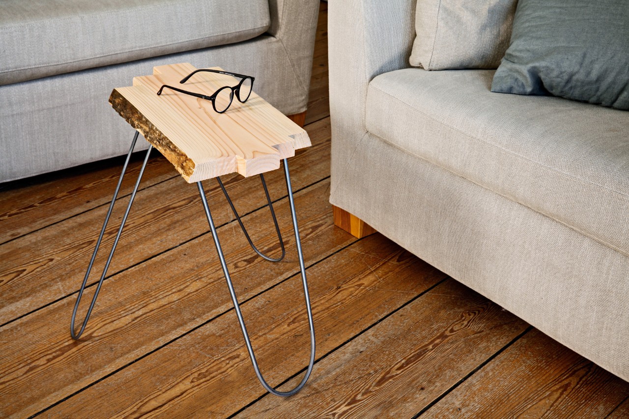A finished DIY side table with a pair of eye glasses sitting on it in a living room