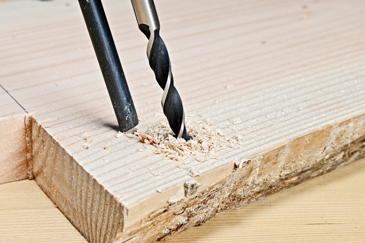 DIY side table: a hole being drilled into a plank at an angle