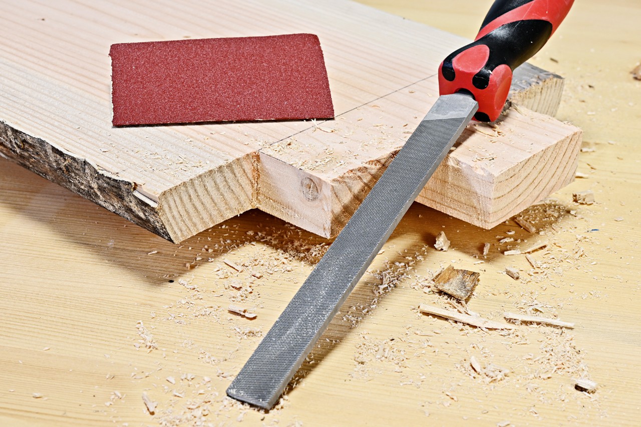 DIY side table: corners of a cut plank being filed