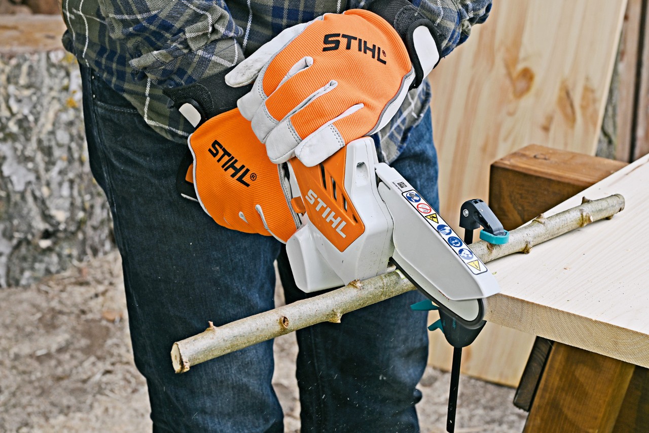 DIY table lamp from twigs: a branch on a workbench being cut to length with the STIHL GTA 26 cordless garden pruner
