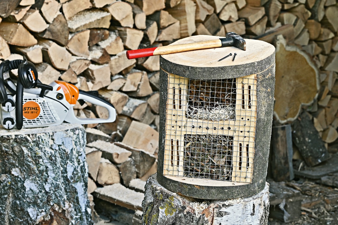 A hammer on a finished DIY bug hotel, with a STIHL MS 151 C 