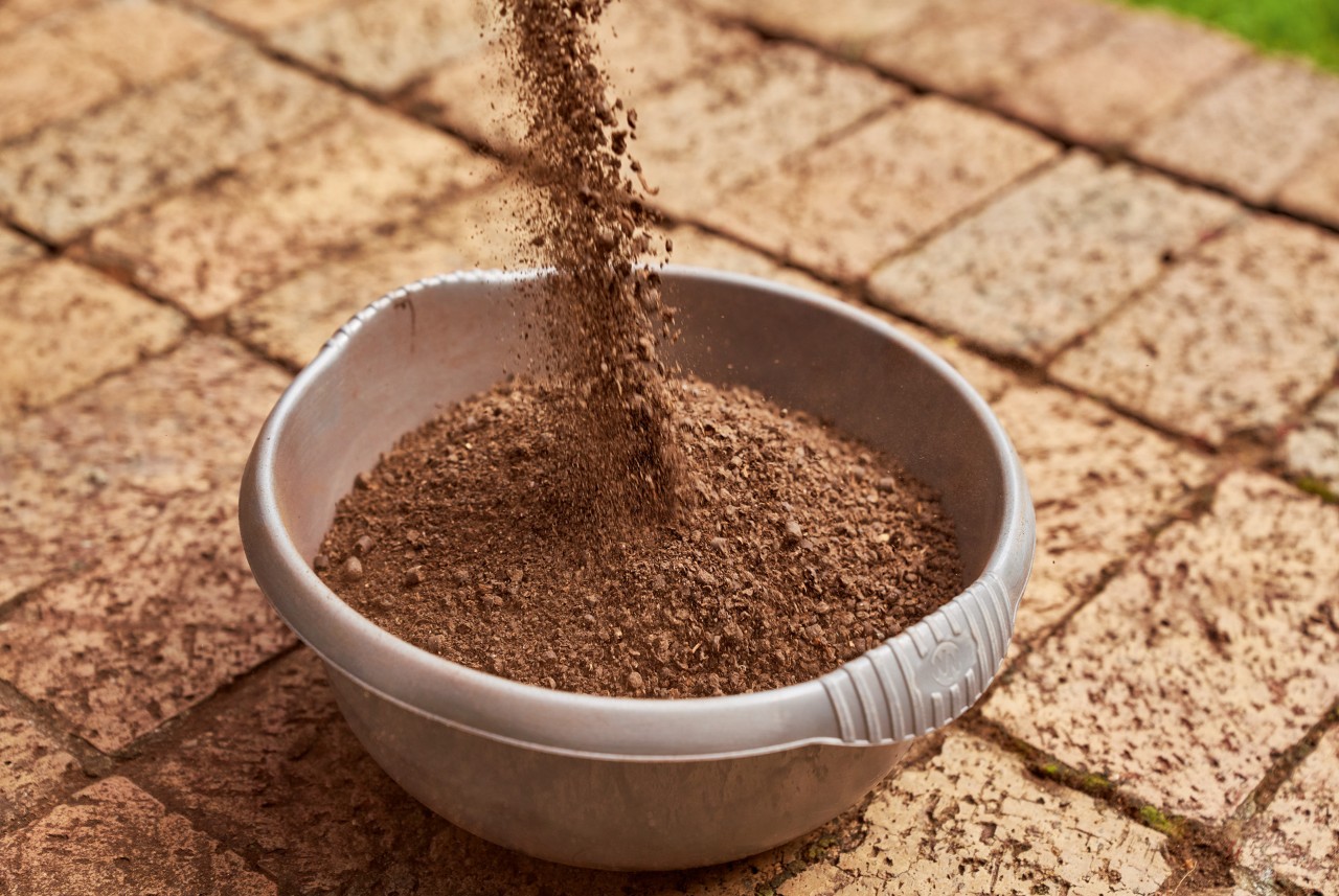 Organic fertiliser being poured into a bowl