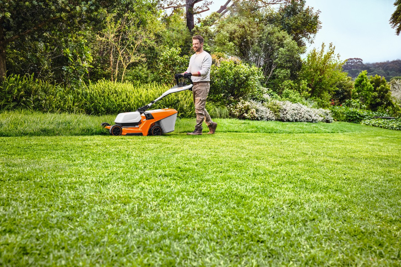 man mowing green lawn with STIHL RMA 448 PV lawn mower