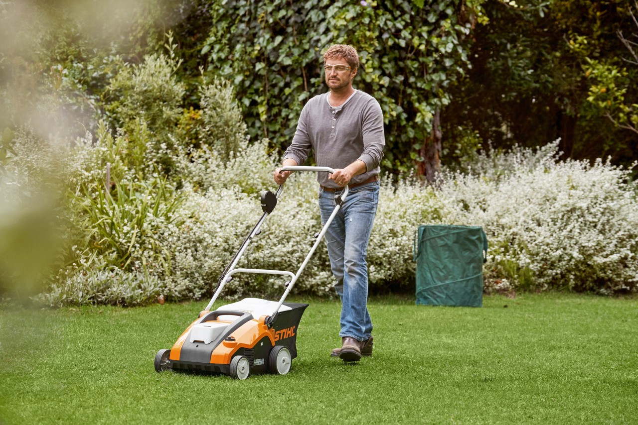Man scarifies lawn before fertilising with a STIHL RLE 240