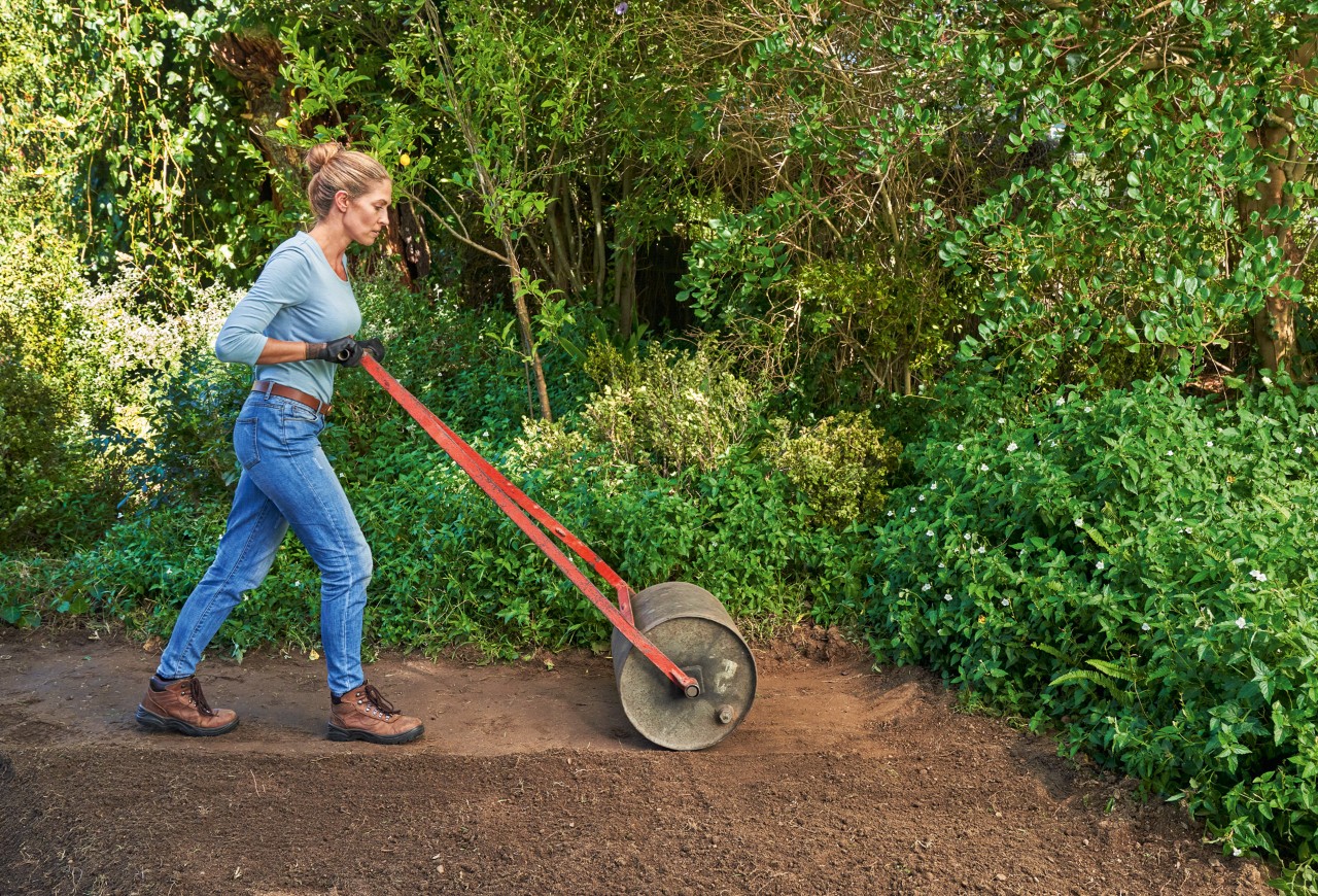 Woman levels the ground with a roller