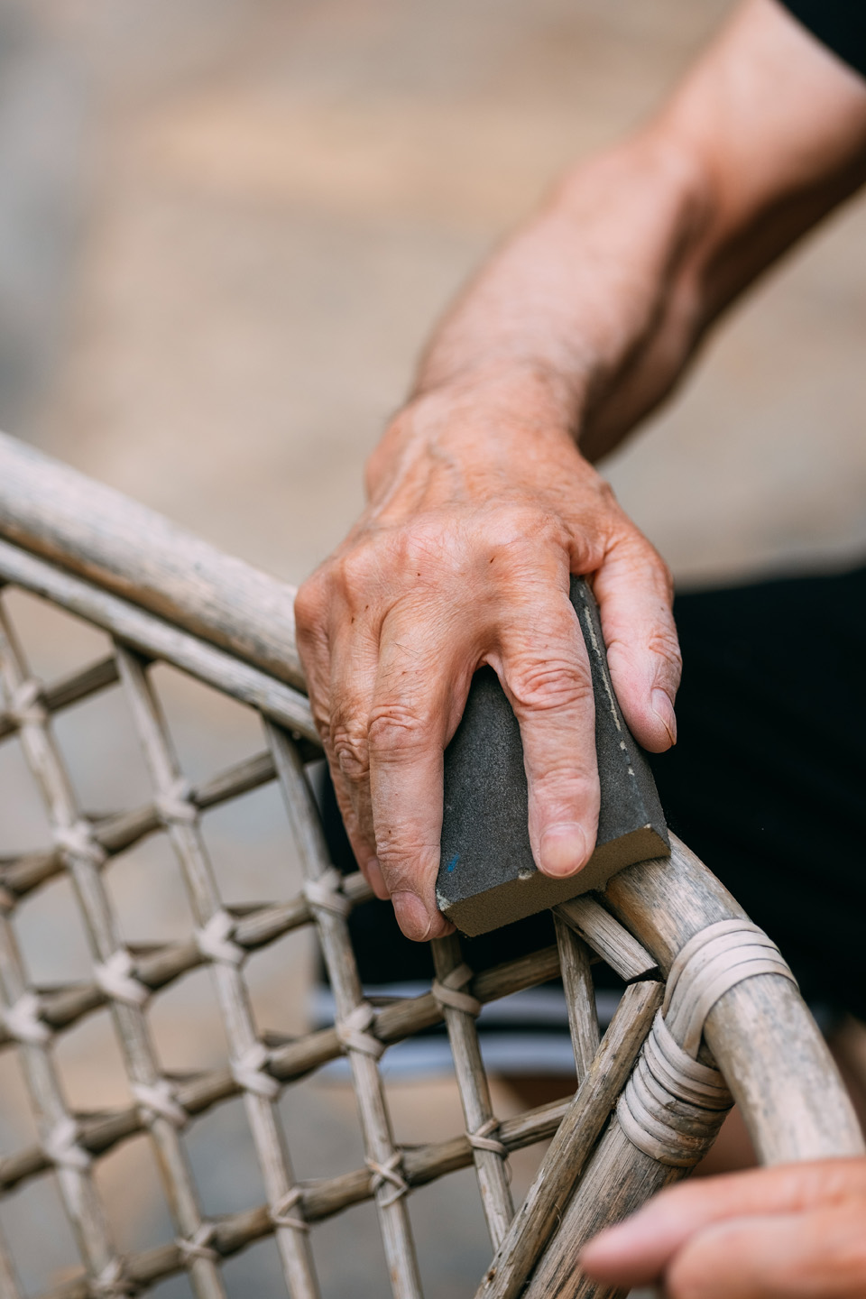 Close-up of a cane garden chair being sanded 