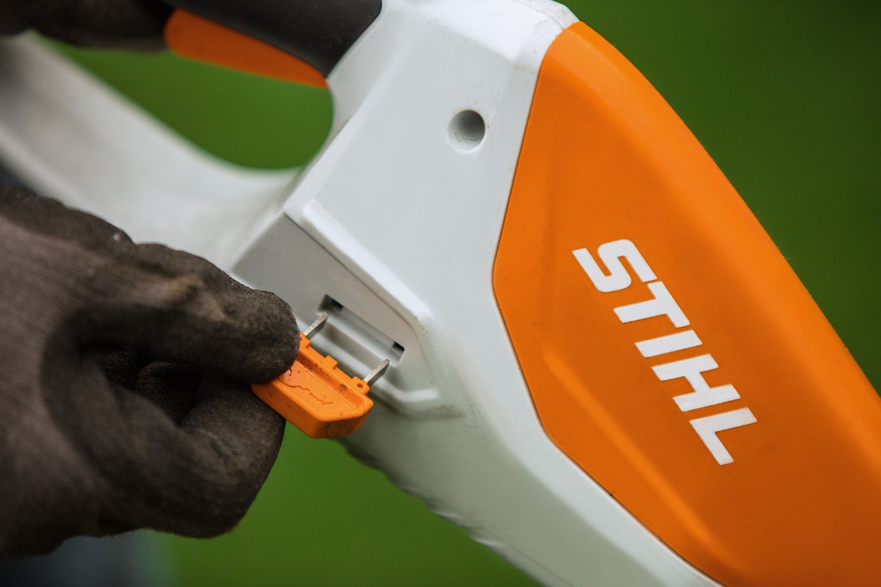 Close-up of the activation key on a STIHL cordless grass trimmer with integrated battery