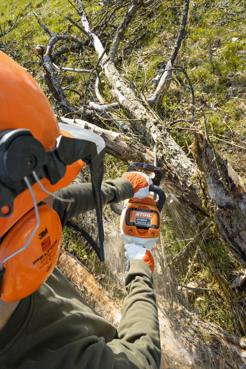 A STIHL MSA 220 C-B cordless chainsaw being used to take branches off a tree trunk
