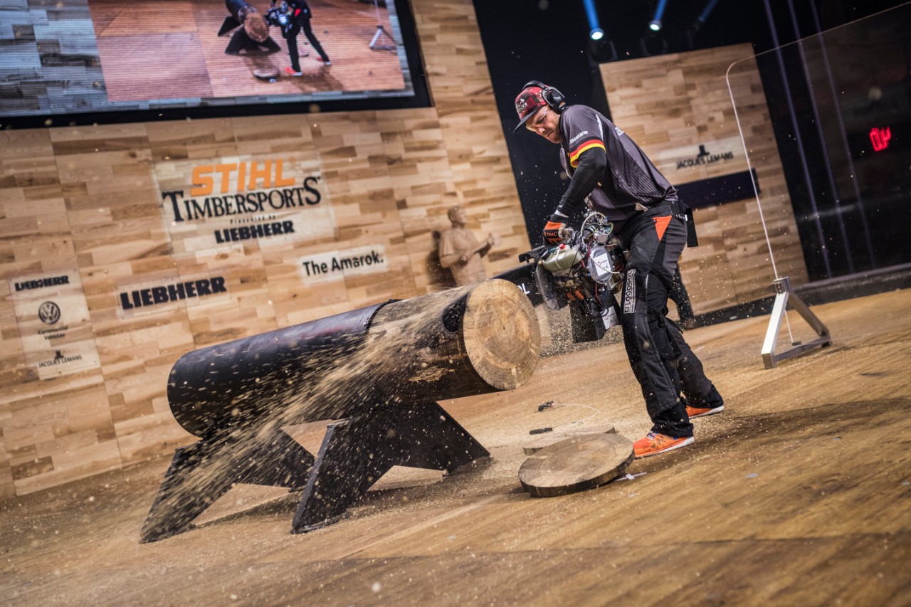 A lumberjack cuts slices from a trunk on-stage at the STIHL TIMBERSPORTS® World Championship 2018 in Liverpool