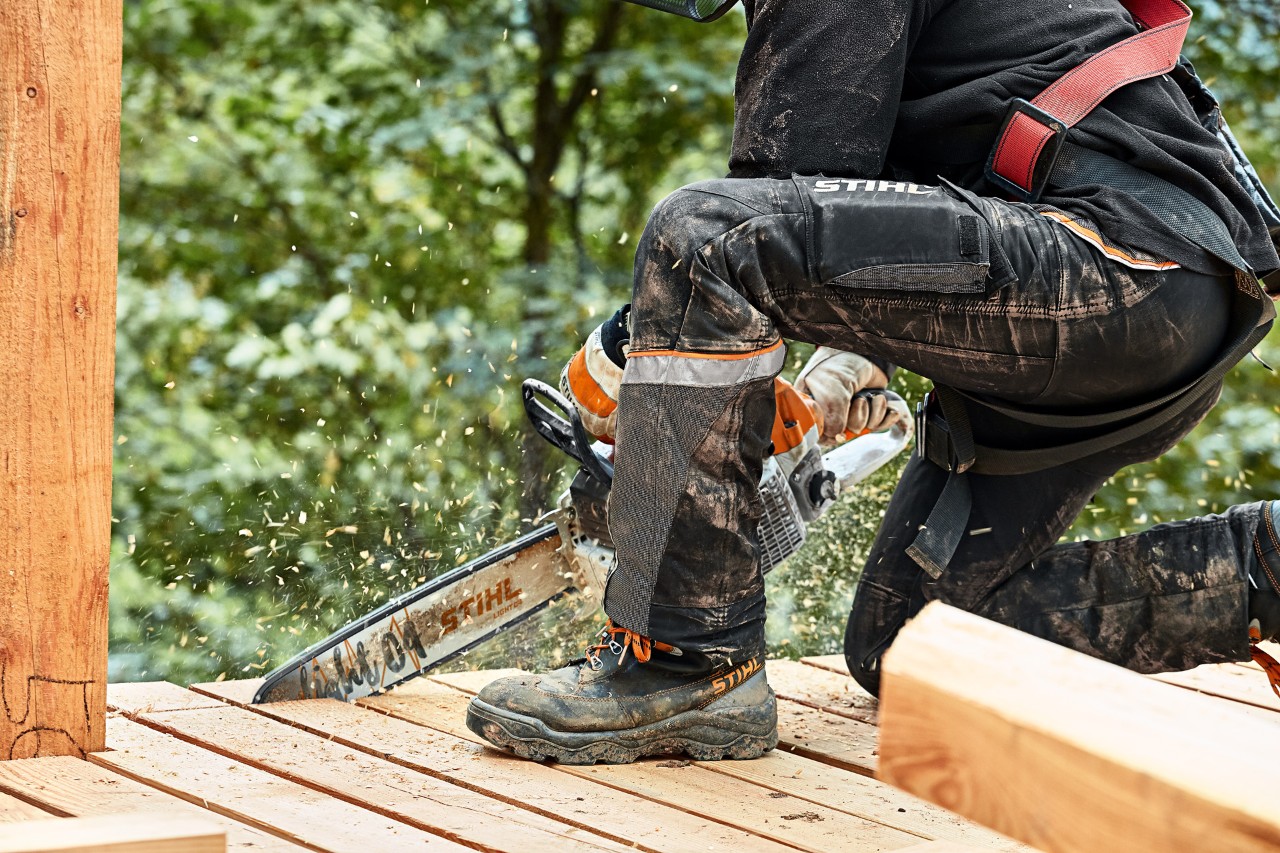 Someone is trimming wooden planks using a STIHL MS 261 chainsaw and wearing STIHL ADVANCE X LIGHT protective trousers
