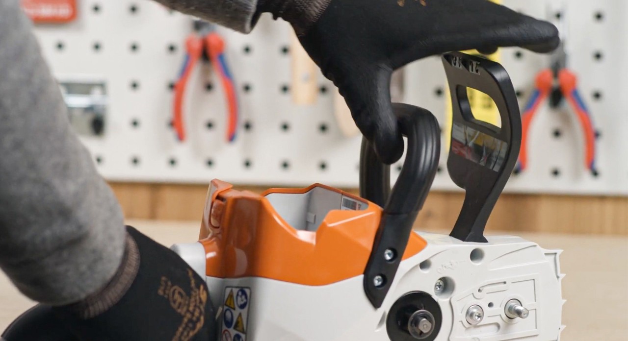 The chain brake on a STIHL MSA 120 cordless chainsaw being released