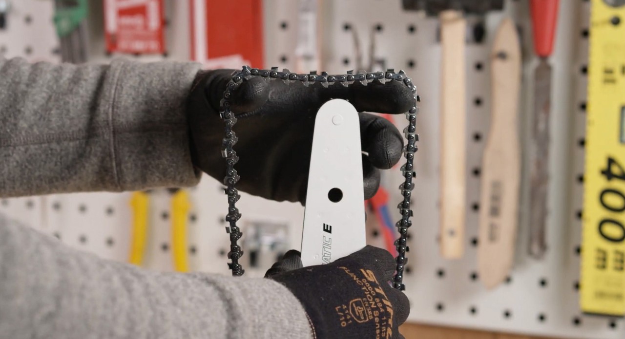 A saw chain being put onto a guide bar