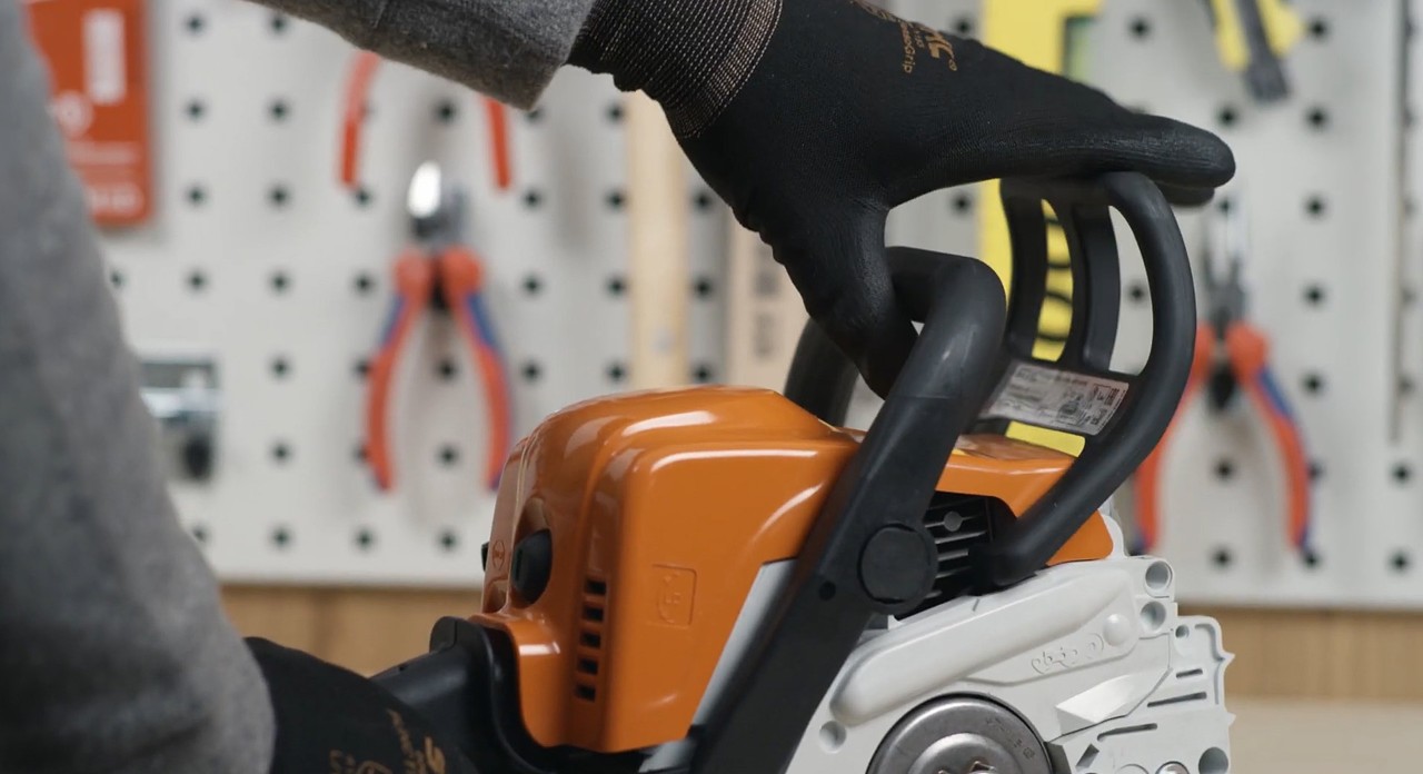 The chain brake on a STIHL MS 170 cordless chainsaw being released