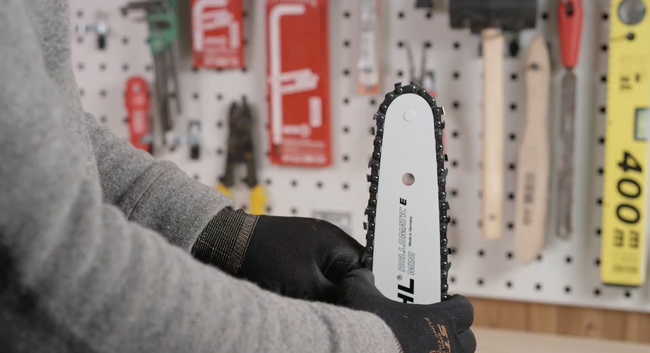 A saw chain being fitted on the guide bar of a STIHL MS 170 cordless chainsaw