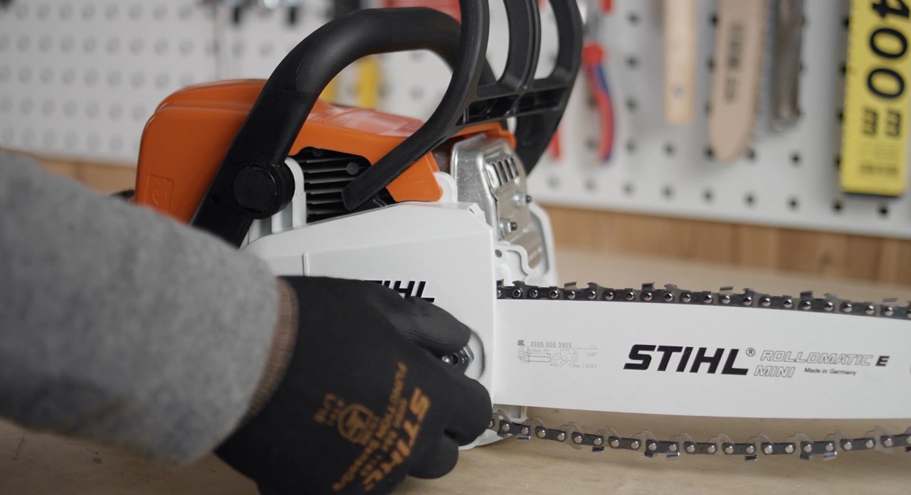The sprocket cover of a STIHL MS 170 cordless chainsaw being fitted