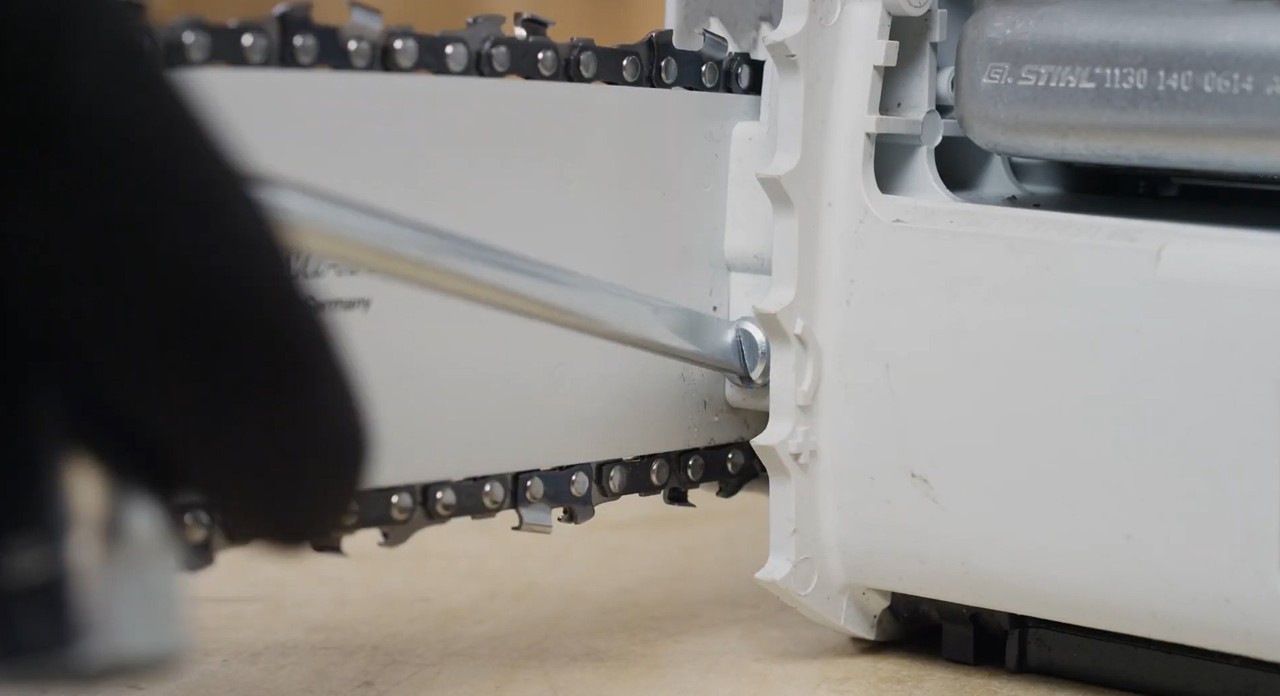 The saw chain of a STIHL MS 170 cordless chainsaw being tightened