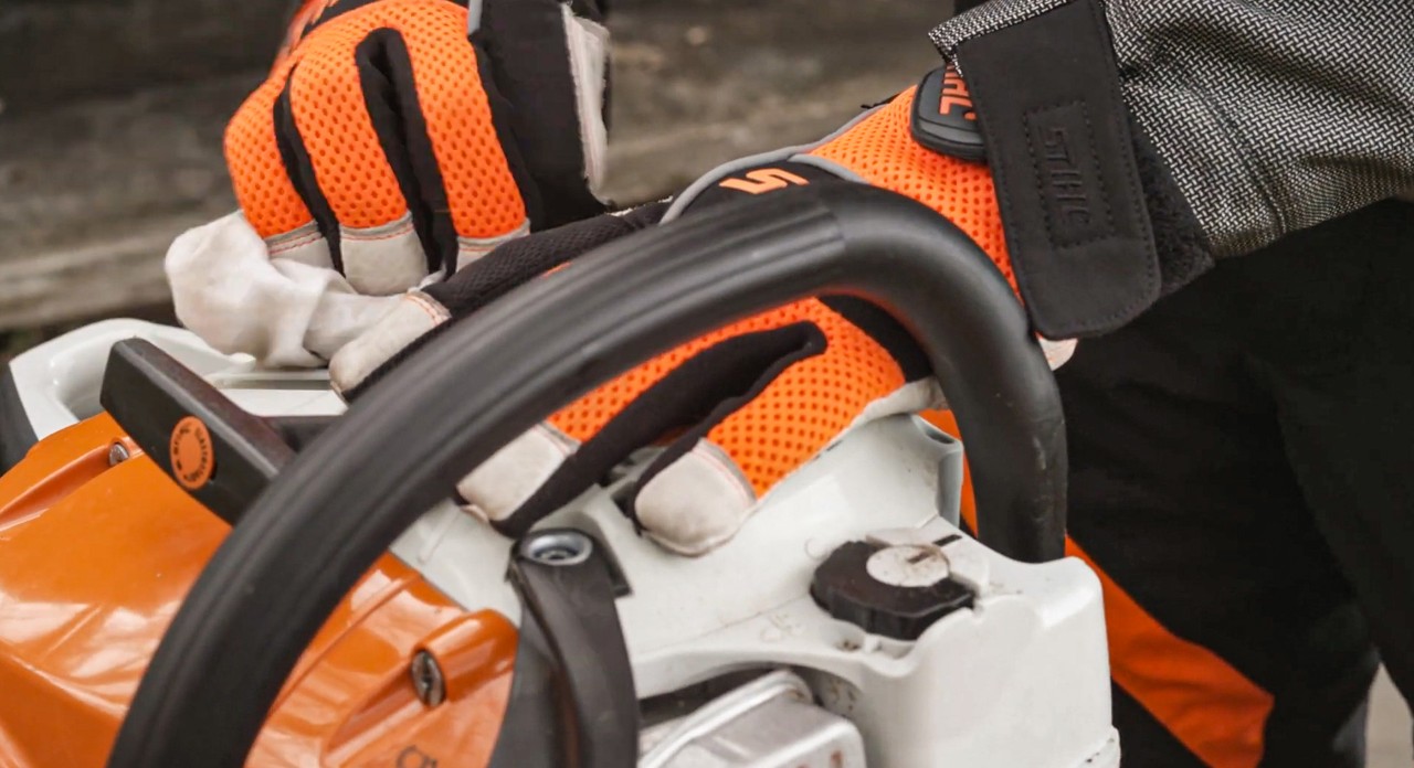 Fuel tank of a STIHL MSA 251 chainsaw being wiped with a cloth