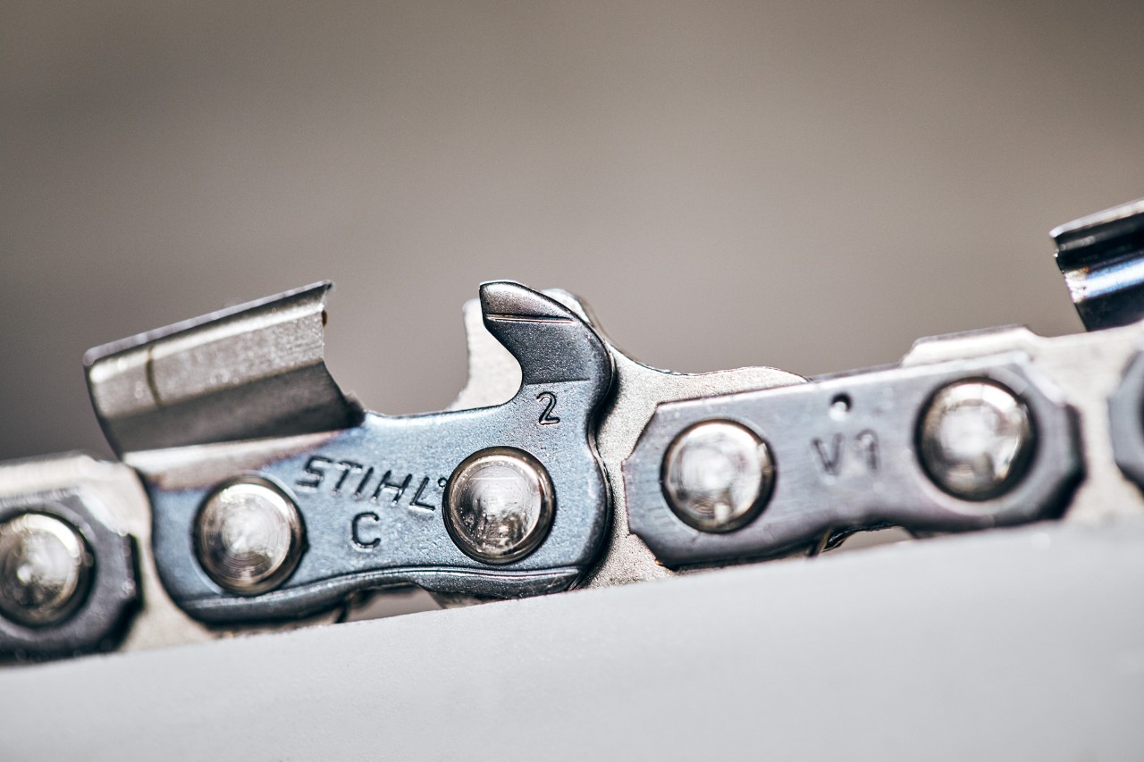 Close-up of saw chain links showing code identifying the chain pitch