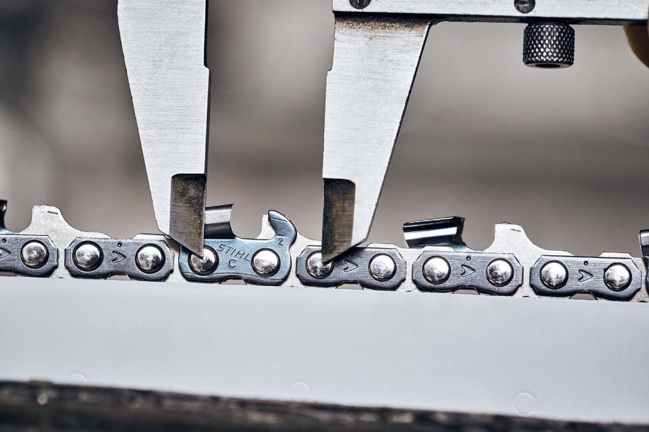 Close-up of calliper being used to measure chain pitch