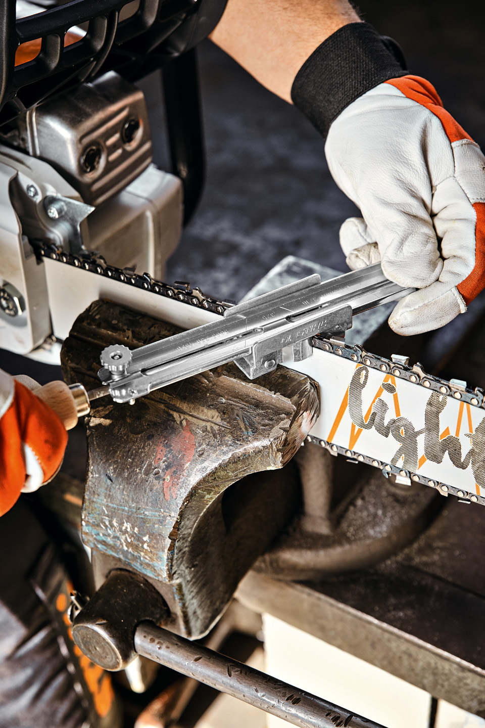 Close-up of a STIHL file holder guide being positioned on a STIHL Light 04 guide bar in a clamp