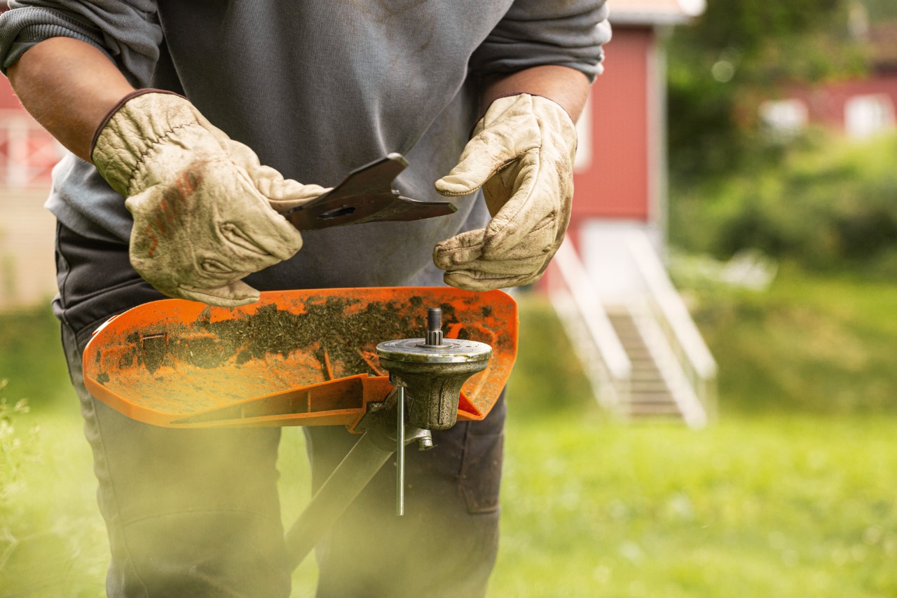 A new cutting tool is placed on the pressure plate of a motor scythe