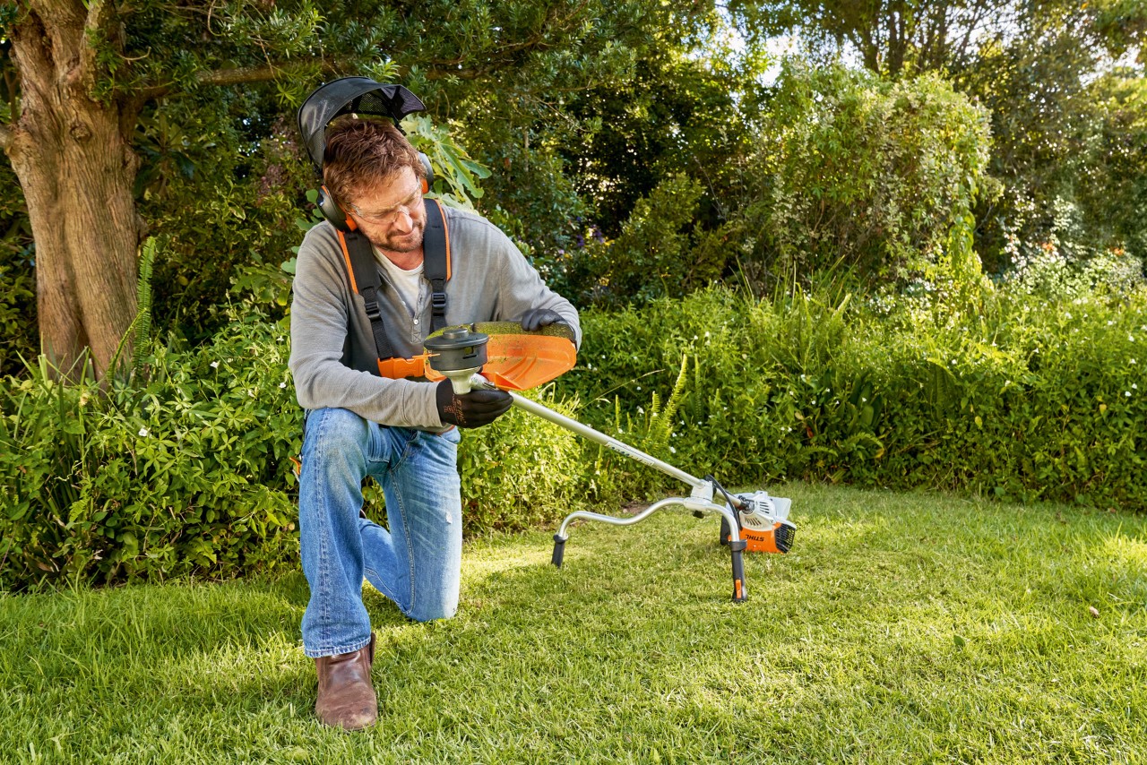 Man prepares to change the wire of a grass trimmer head
