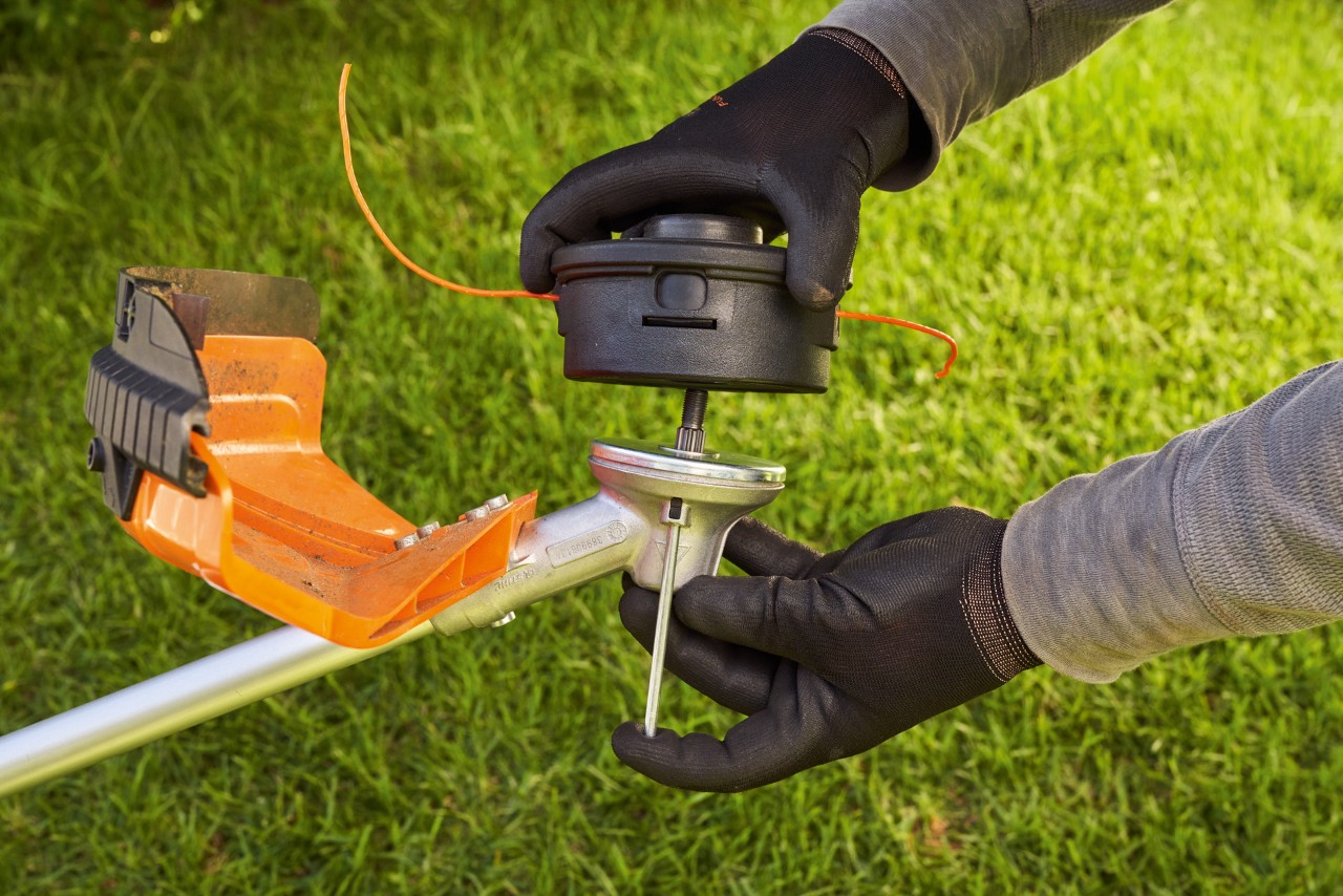 After changing the cutting tool, the grass trimmer head is tightened with blocked shaft