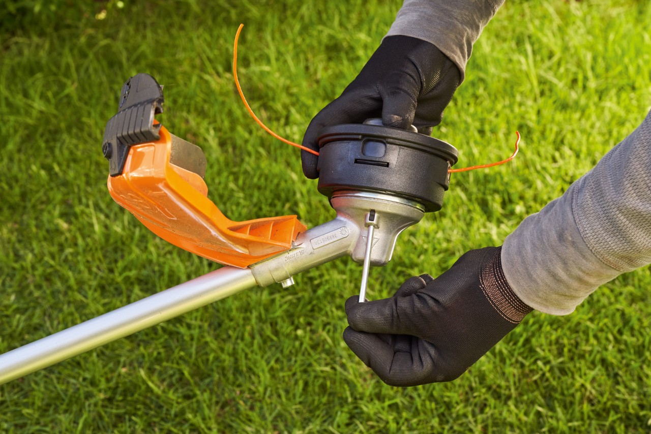 After changing the cutting tool, the grass trimmer head is tightened with blocked shaft