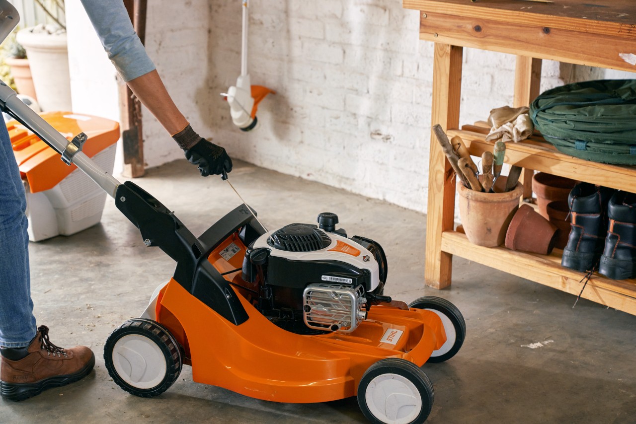 The air filter of a STIHL RM 448 TC petrol lawn mower being cleaned in a garage