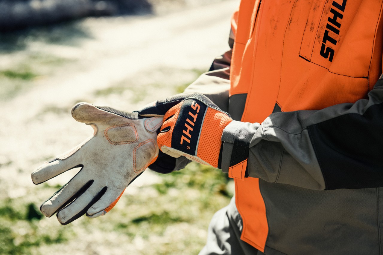 Close-up of someone putting on STIHL work gloves