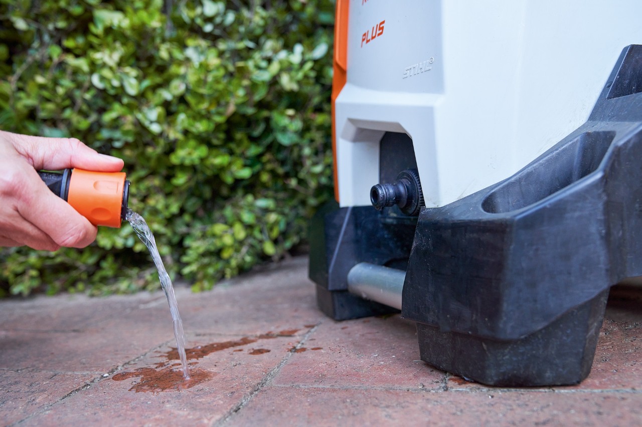 Someone cleaning the water inlet filter of a STIHL RE 130 PLUS high-pressure cleaner for high-pressure cleaner maintenance