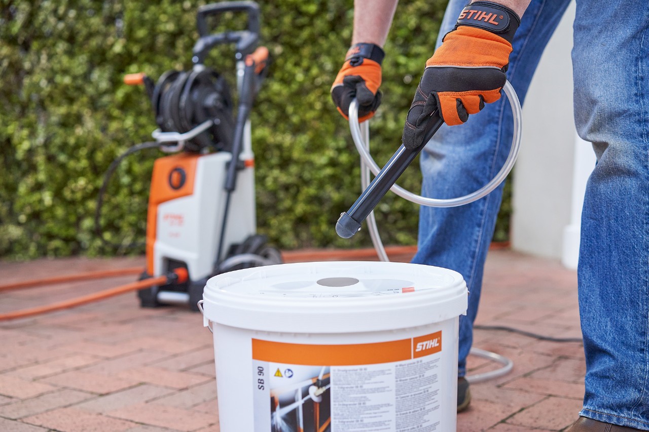 A man wearing protective gloves prepares STIHL SB 90 blasting granulate for wet blasting 