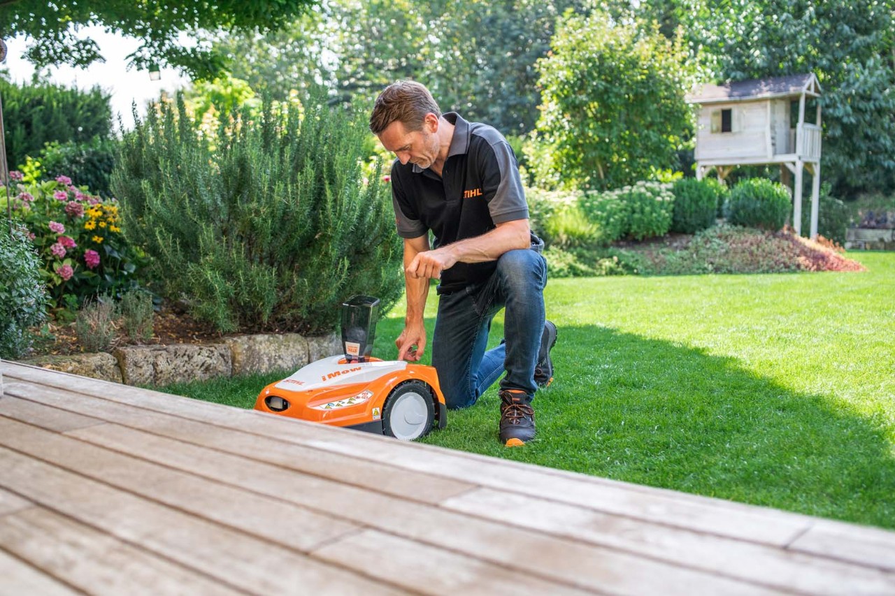 A STIHL dealer sets the dynamic mowing schedule of a STIHL RMI 422 iMOW® robot mower on a green lawn
