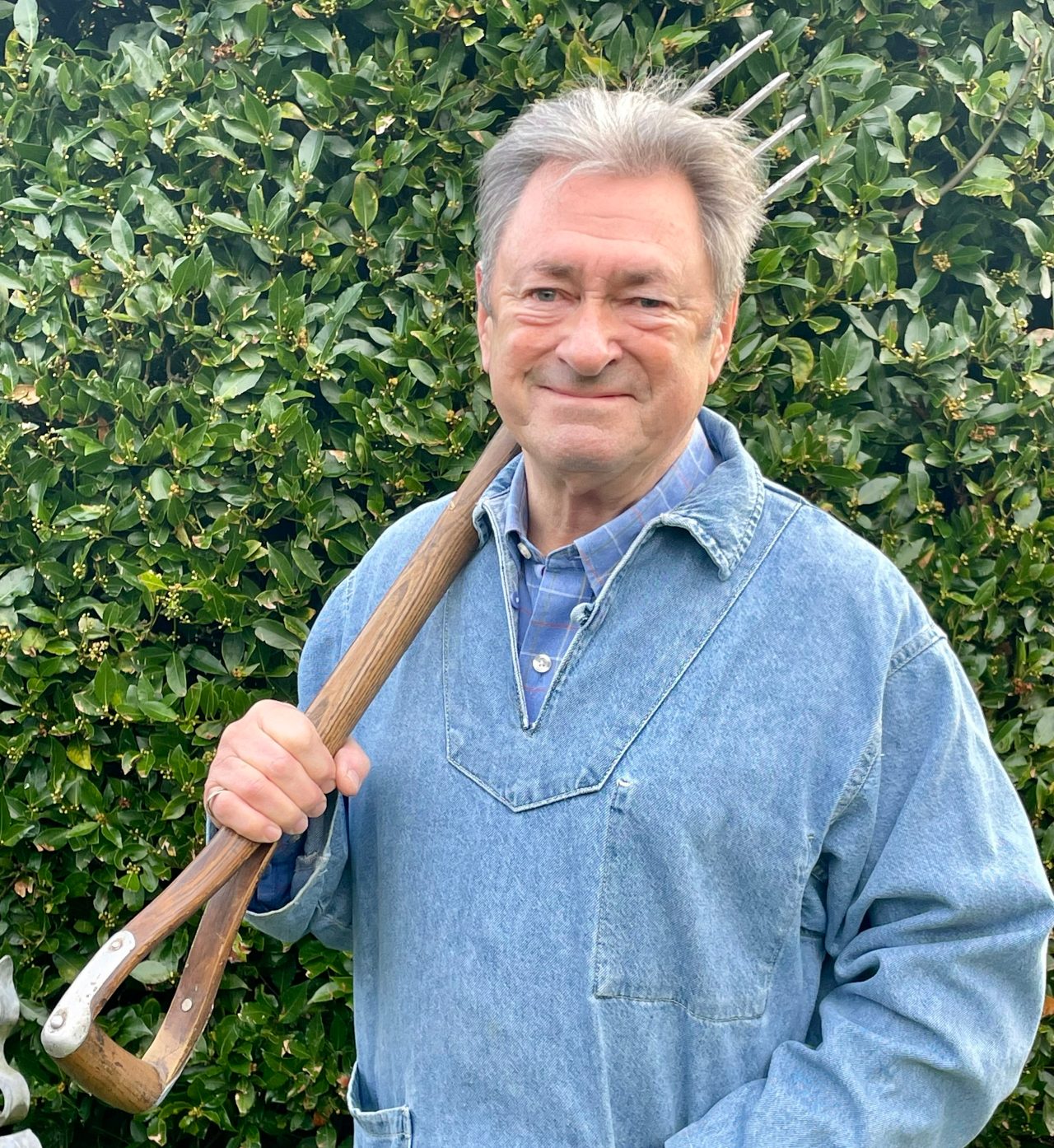 alan titchmarsh with a gardening fork in front of hedge