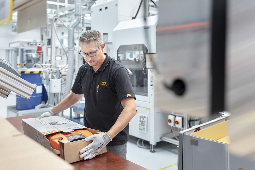 An employee in battery production packs a STIHL cordless tool into a box